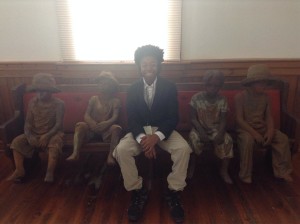 Jordan Bennett at Whitney Plantation with statues of slave children